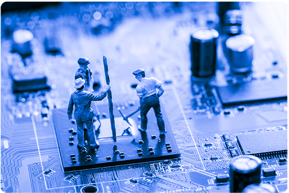 Three toy figurines atop a computer chip on a circuit board